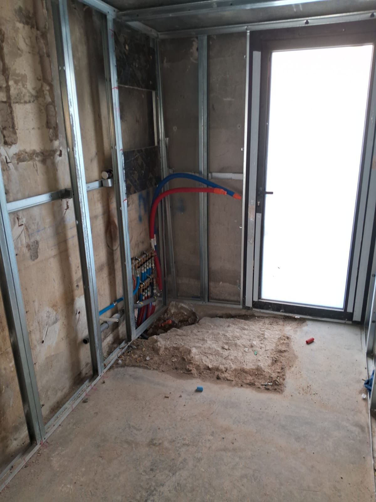 Salle de bain avant travaux : ossature métallique et réseaux à reprendre